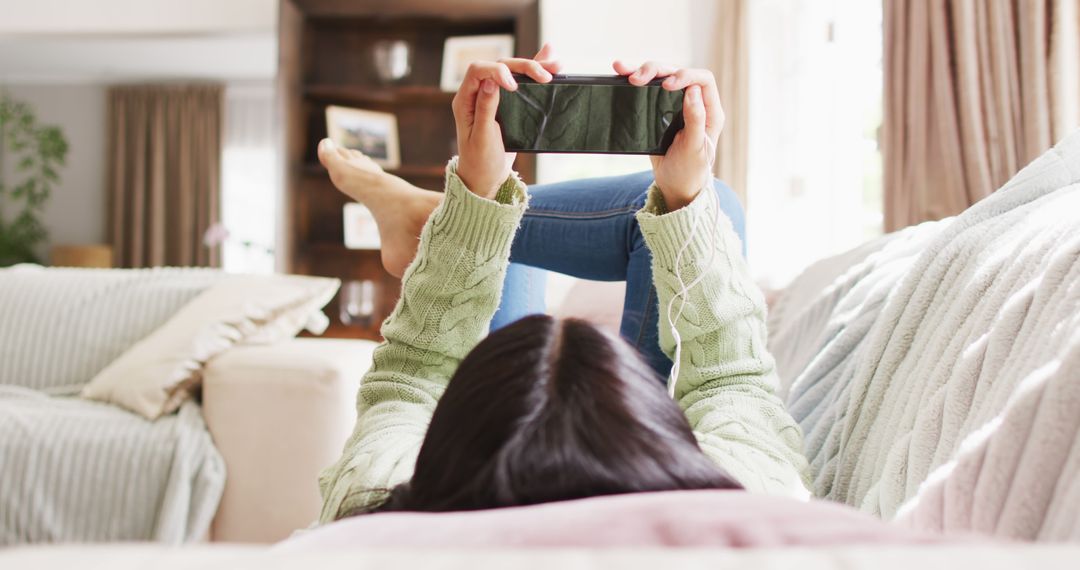 Relaxing Woman Lying on Couch Using Smartphone - Free Images, Stock Photos and Pictures on Pikwizard.com