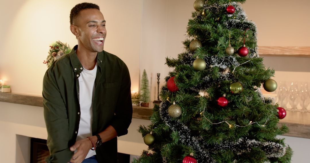 Cheerful Man Celebrating Christmas Beside Festive Tree at Home