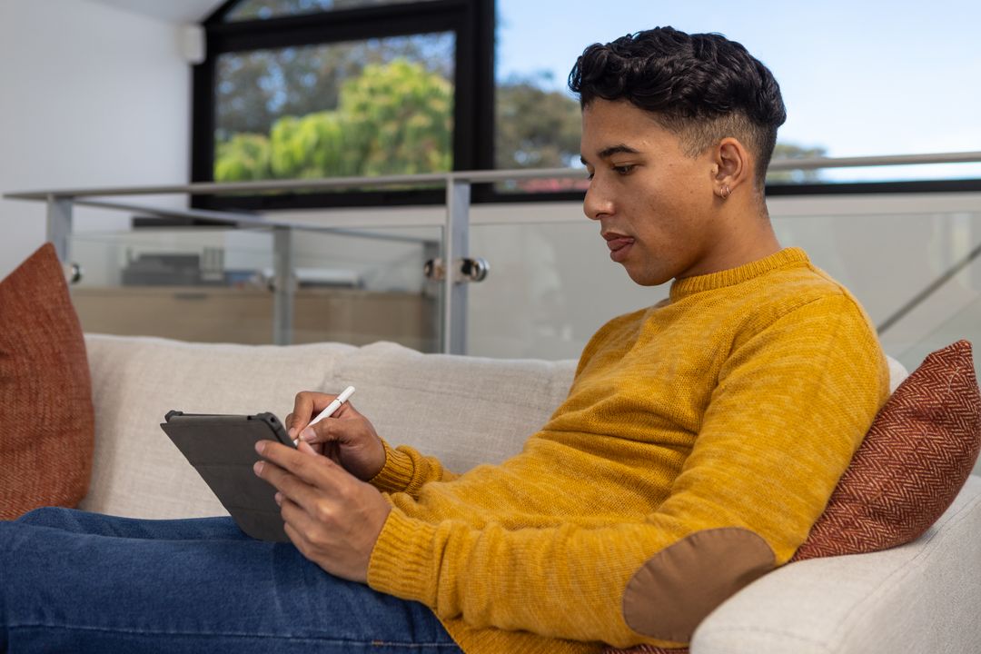 Young Man Relaxing in Loft With Tablet and Stylus