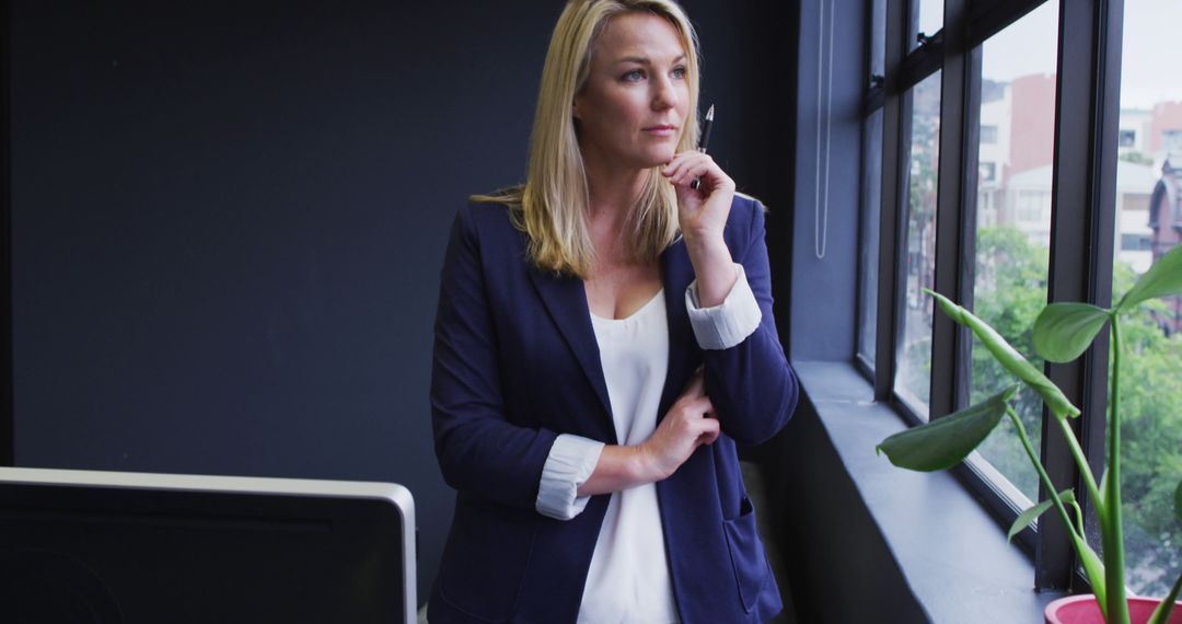 Thoughtful Businesswoman Looking Out of Office Window - Free Images, Stock Photos and Pictures on Pikwizard.com