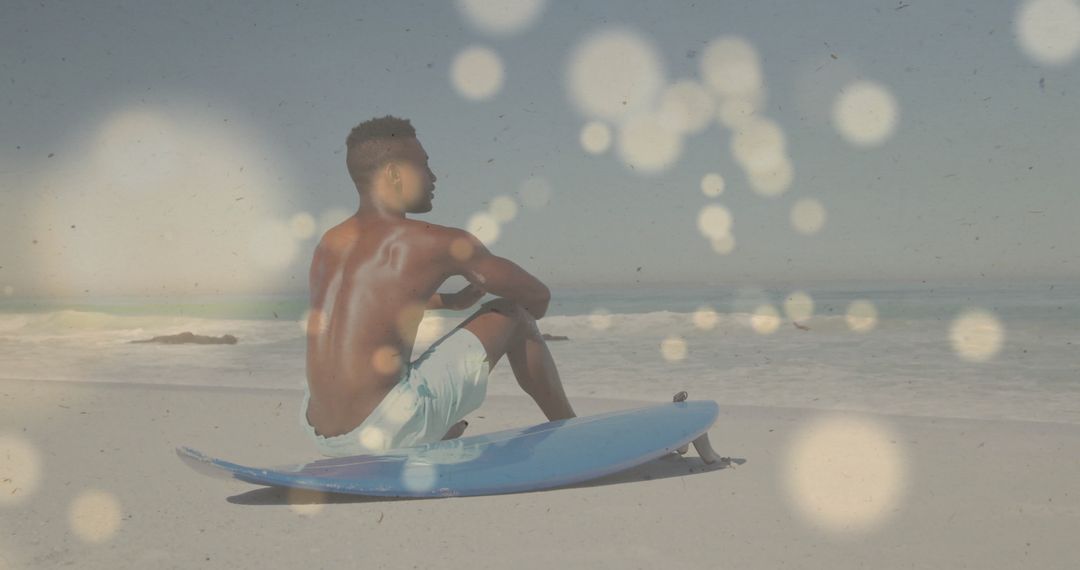 Man Relaxing on Beach with Surfboard Under Sunlit Sky