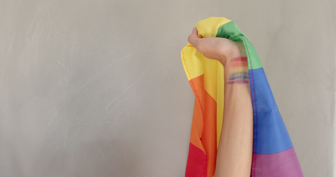 Arm Holding Draped Rainbow Flag with Colorful Arm Painting