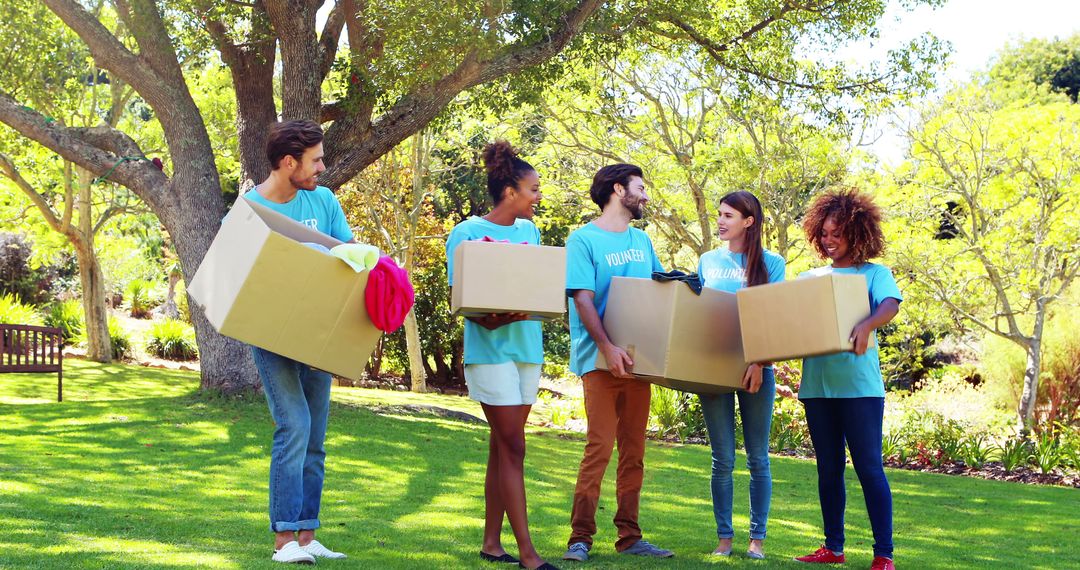 Diverse Group of Volunteers Carrying Donation Boxes in Park - Free Images, Stock Photos and Pictures on Pikwizard.com