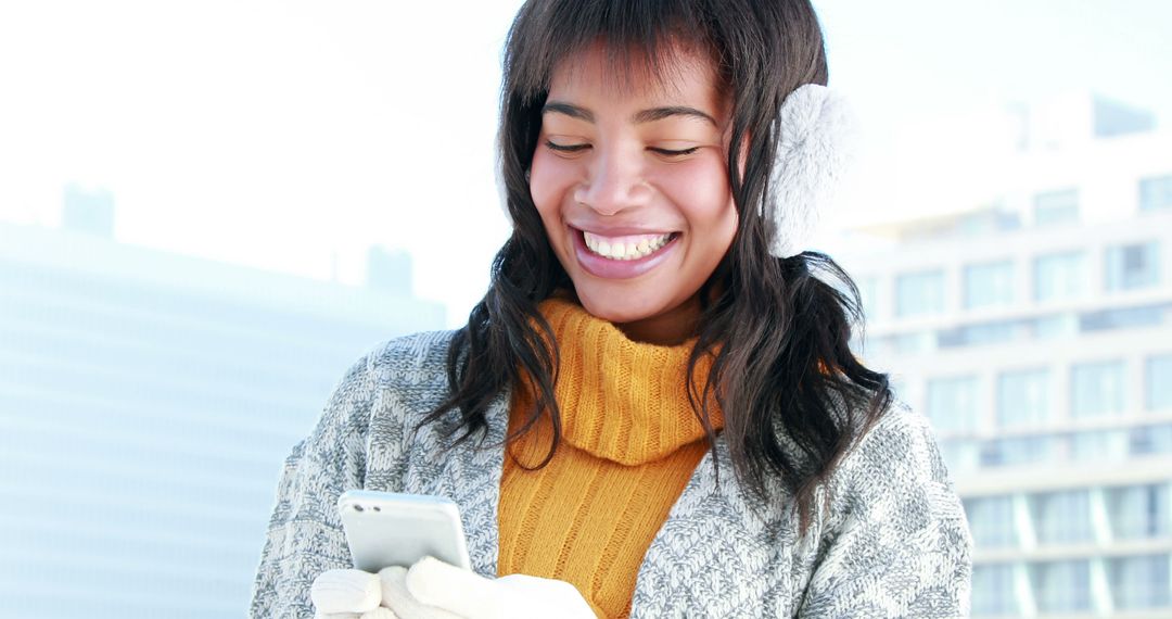 Smiling Young Woman Using Smartphone Outdoors in Winter - Free Images, Stock Photos and Pictures on Pikwizard.com