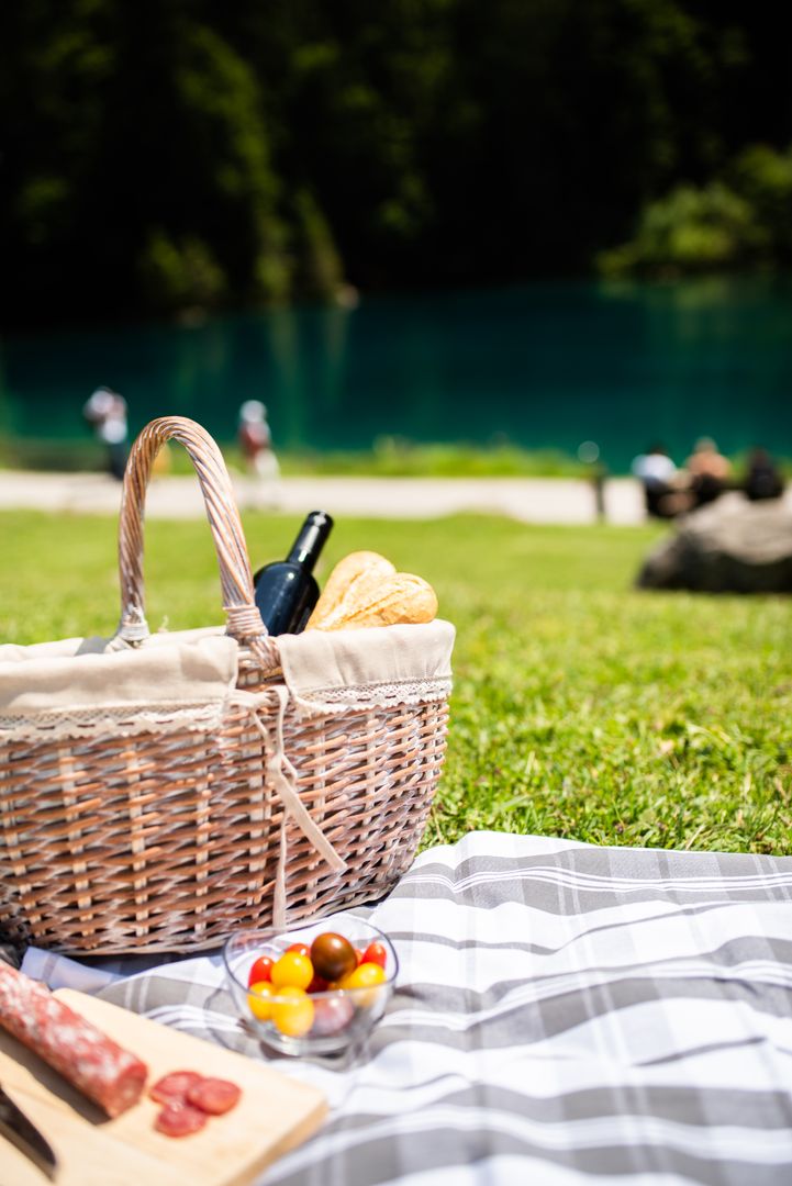 Picnic Basket with Wine and Bread Near Scenic Lake