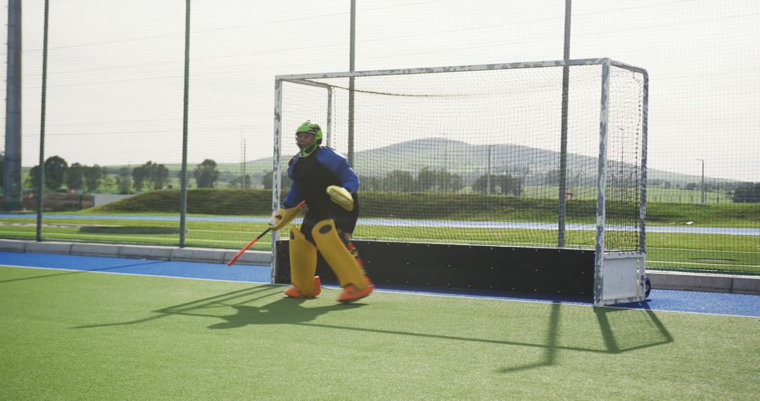 Field Hockey Goalkeeper Preparing for Action on Sunny Field
