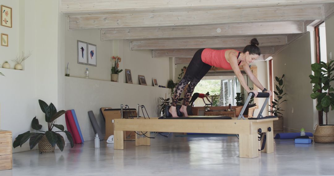 Woman Practicing Pilates on Reformer in Home Gym - Free Images, Stock Photos and Pictures on Pikwizard.com