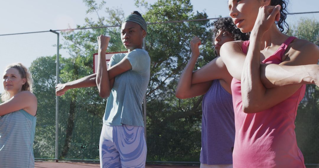 Diverse Female Athletes Stretching on Sunny Basketball Court - Free Images, Stock Photos and Pictures on Pikwizard.com