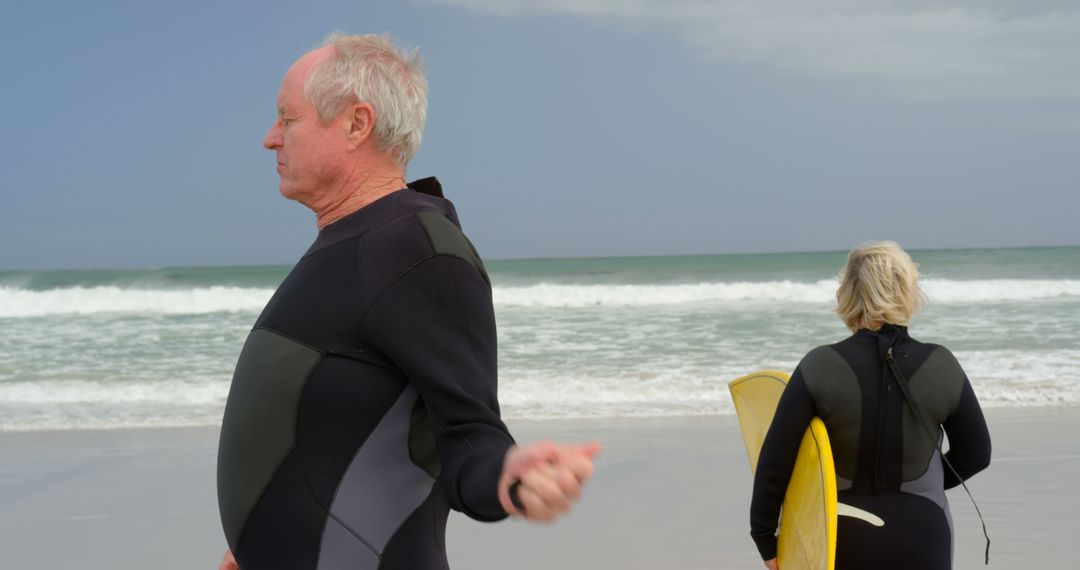 Seniors Enjoying Surfing at the Beach in Wetsuits - Free Images, Stock Photos and Pictures on Pikwizard.com