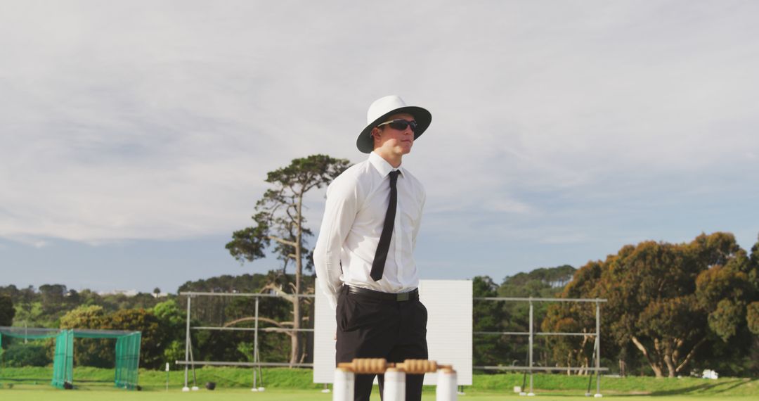 Cricket Umpire Standing Alertly during Match on Sunny Day