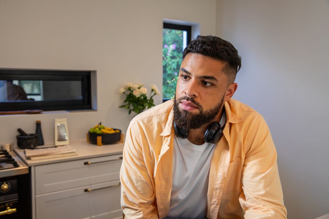 Man Relaxing in Contemporary Kitchen with Headphones and Fruit Bowl