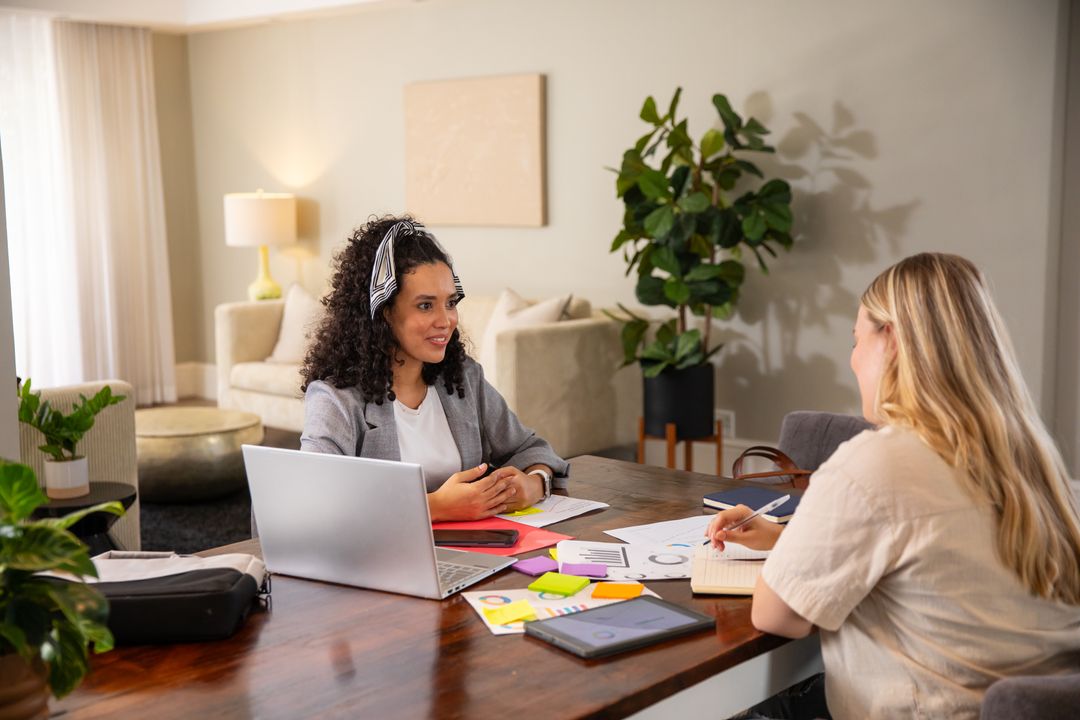 Two Diverse Female Coworkers Collaborating on Business Strategy at Home