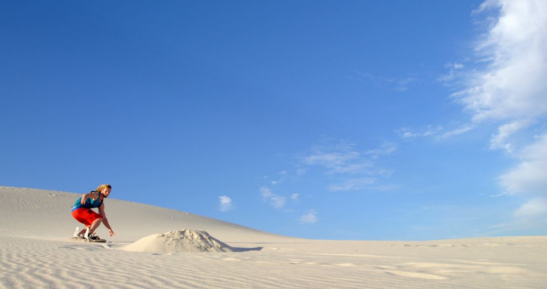 Adventurous Young Man Sandboarding on Scenic Desert Dune