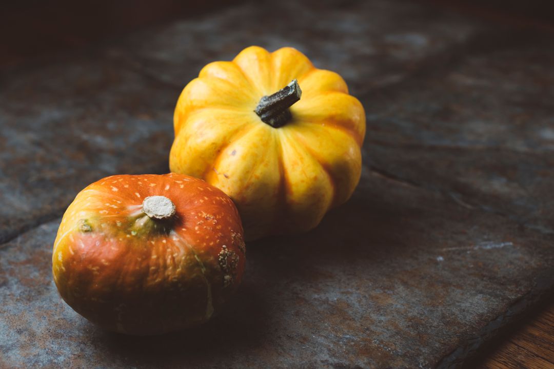 Two Autumn Pumpkins on Rustic Surface