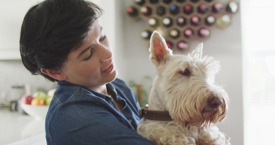 Caucasian woman kissing her dog in the living room at home - Free Images, Stock Photos and Pictures on Pikwizard.com