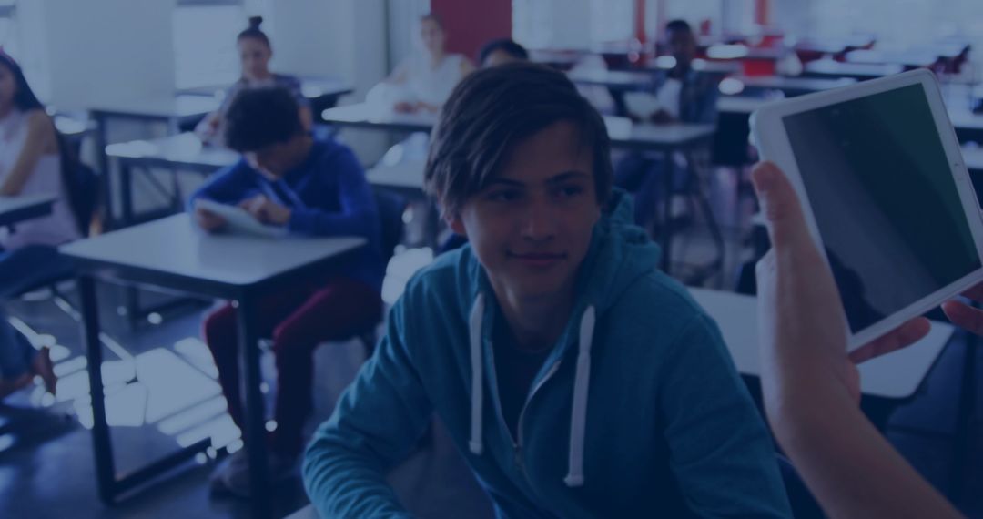 Teen Student Looking at Tablet During Interactive Classroom Technology Lesson