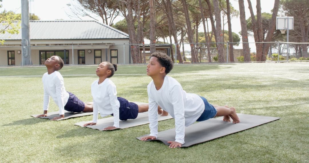 Children Practicing Upward-Facing Dog Pose on Outdoor Filed
