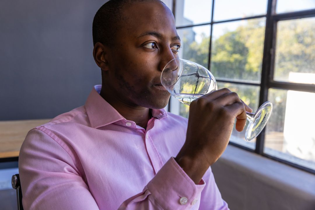 Man Sipping Wine in Elegant Cafe by Window