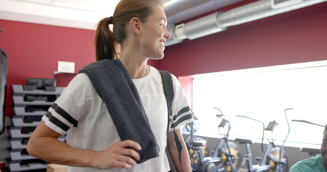 Fit Woman Preparing for Workout in Gym with Towel and Bottle