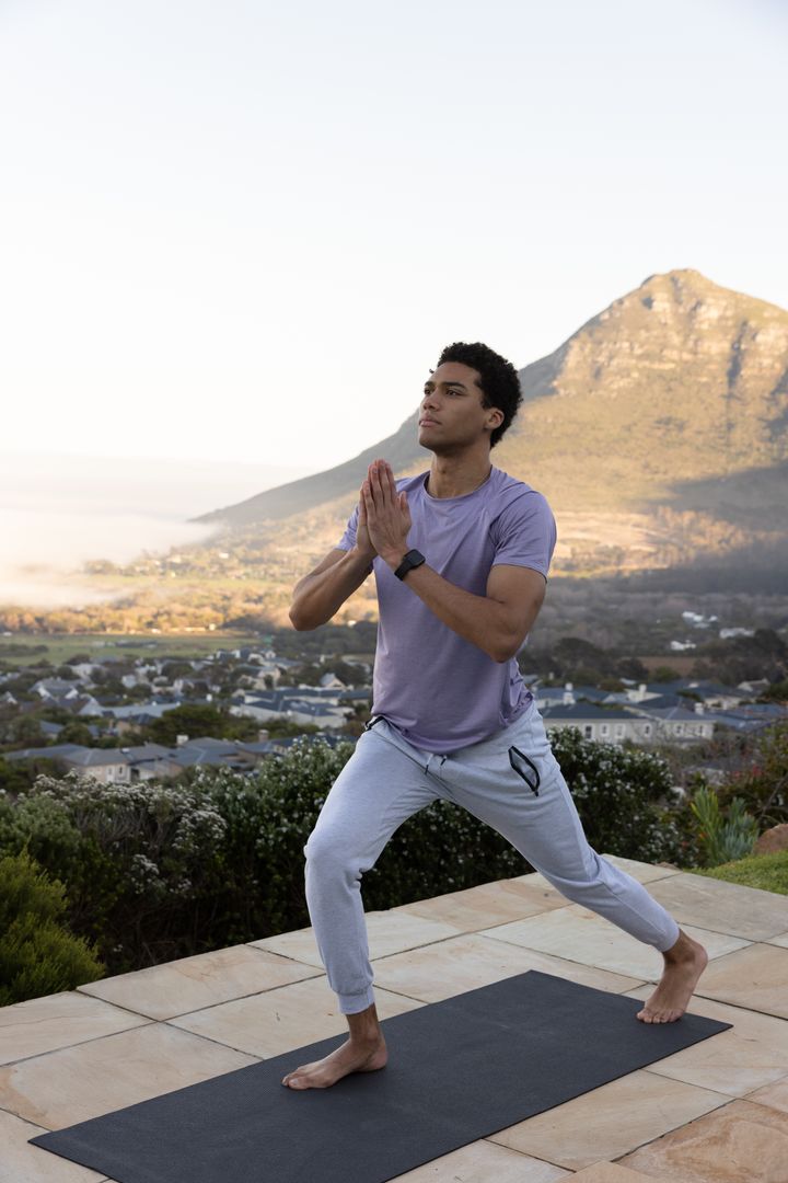 Afro Descendant Man Practicing Yoga Outdoors with Mountain View