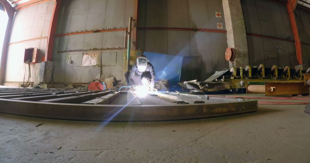 Welder Working with Bright Sparks in Industrial Warehouse - Free Images, Stock Photos and Pictures on Pikwizard.com