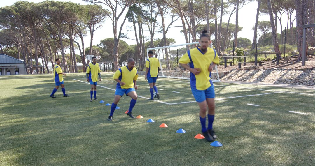 Soccer Players in Agility Training with Cones on Sunlit Field