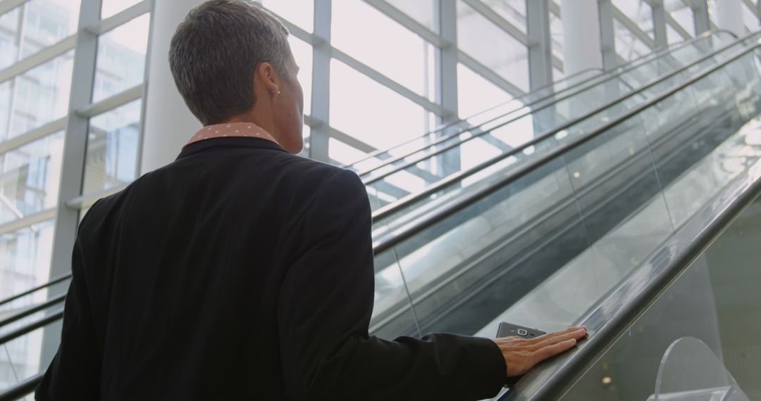 Business Professional on Escalator in Modern Office Building - Free Images, Stock Photos and Pictures on Pikwizard.com