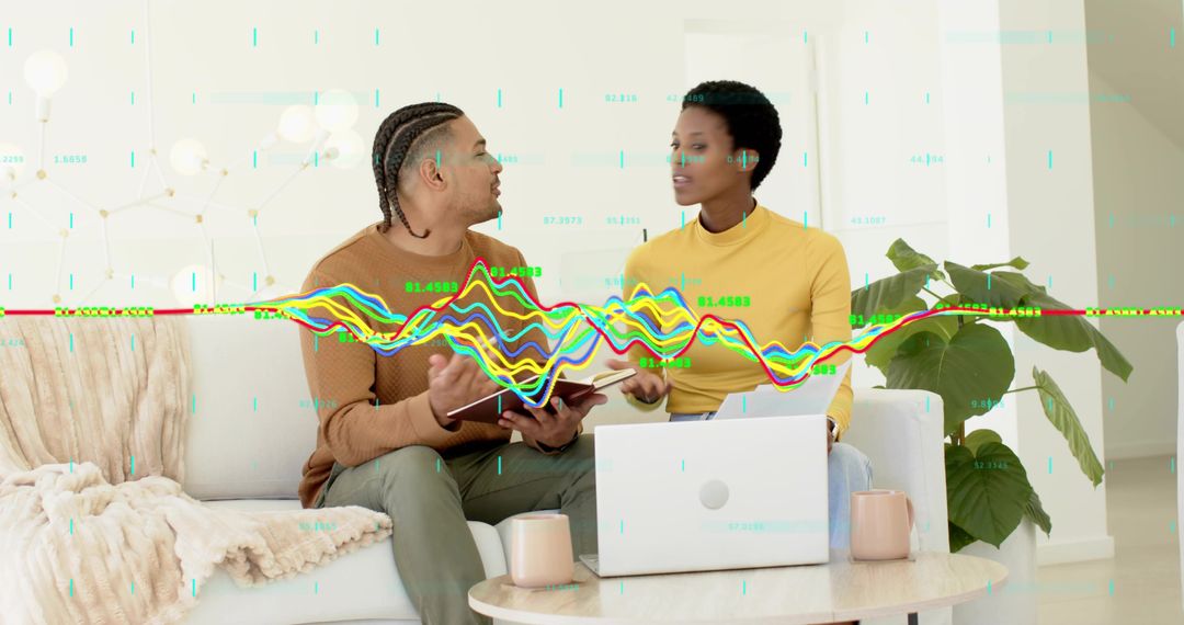 Colleagues discussing analytics and reviewing colorful data visualization with laptop