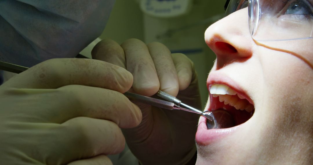 Dentist Examining Female Patient's Teeth with Dental Tools - Free Images, Stock Photos and Pictures on Pikwizard.com