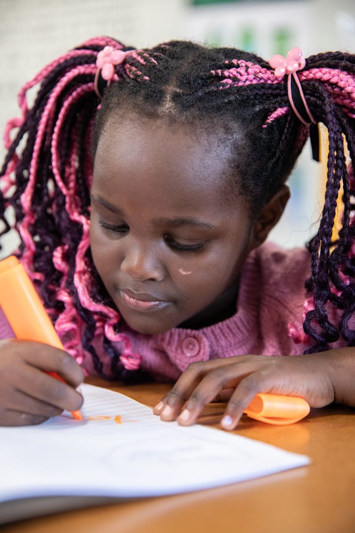 Young African American Girl Using Highlighter while Studying at Desk
