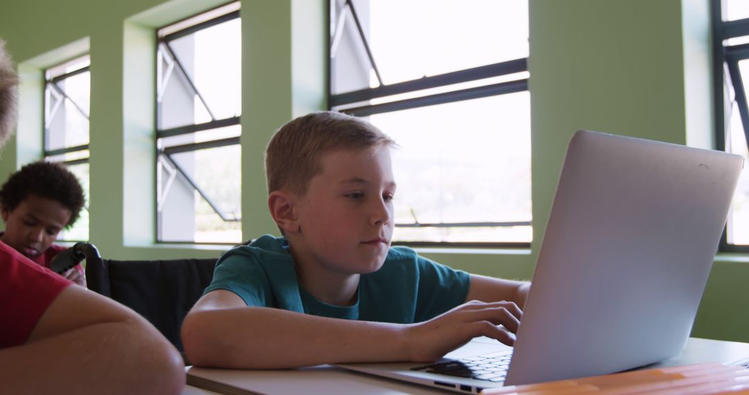 Focused Schoolboy Using Laptop Indoors Classroom Environment