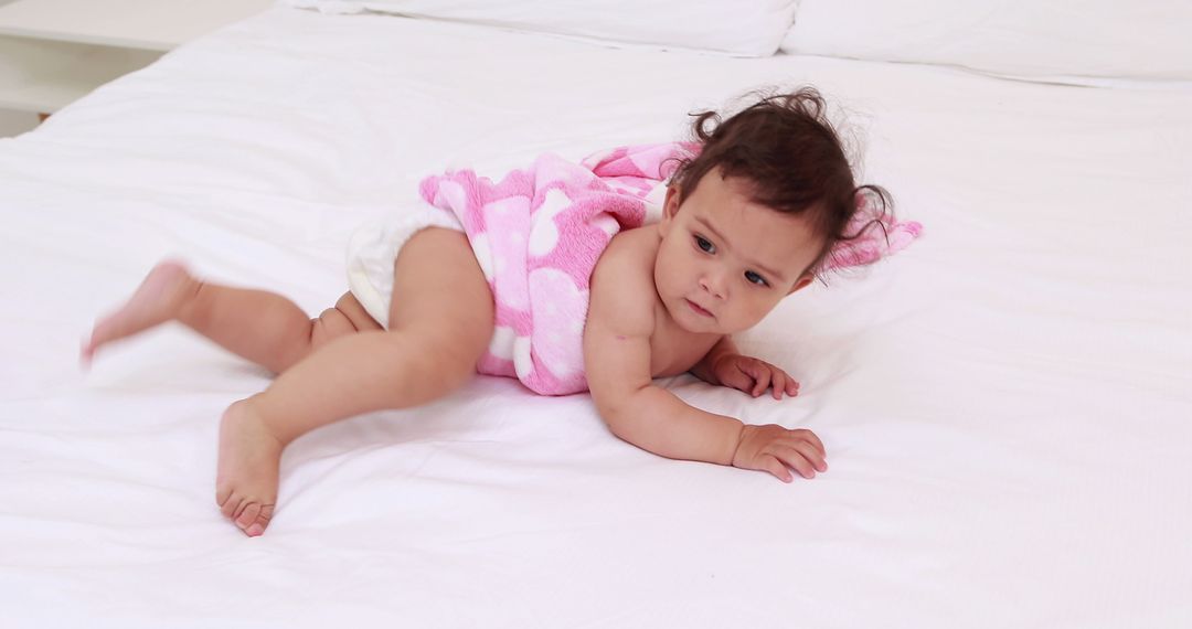 Adorable Baby Resting on Bed with Pink Blanket