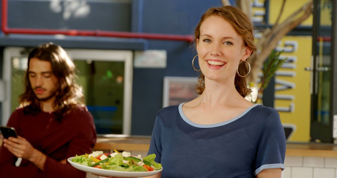 Smiling Waitress Holding Fresh Salad in Modern Restaurant - Free Images, Stock Photos and Pictures on Pikwizard.com