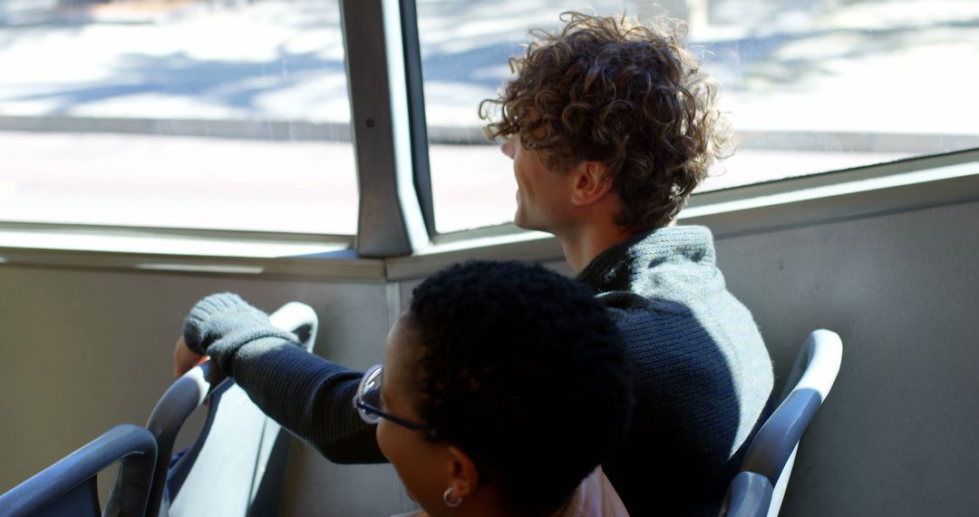 Two People Sitting by Bus Window Enjoying Sunny Day - Free Images, Stock Photos and Pictures on Pikwizard.com