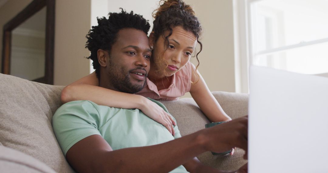 Couple Relaxing with Laptop while Woman Embraces Partner