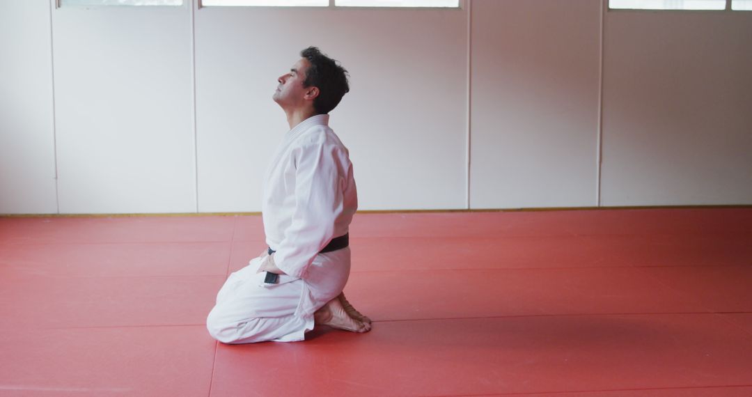 Man Meditating in Martial Arts Dojo with White Gi - Free Images, Stock Photos and Pictures on Pikwizard.com