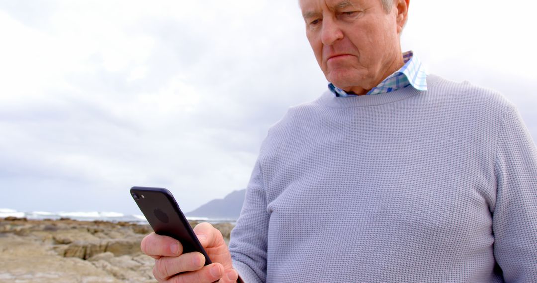 Senior Man Using Smartphone Outdoors Near Ocean - Free Images, Stock Photos and Pictures on Pikwizard.com