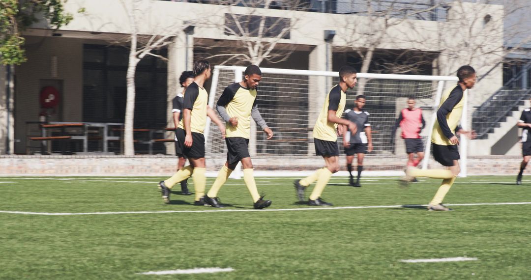 Soccer Players Preparing on Field in Black and Yellow Uniforms