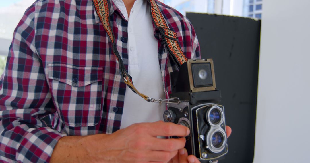 Photographer Holding Vintage Twin-Lens Reflex Camera in Urban Area - Free Images, Stock Photos and Pictures on Pikwizard.com