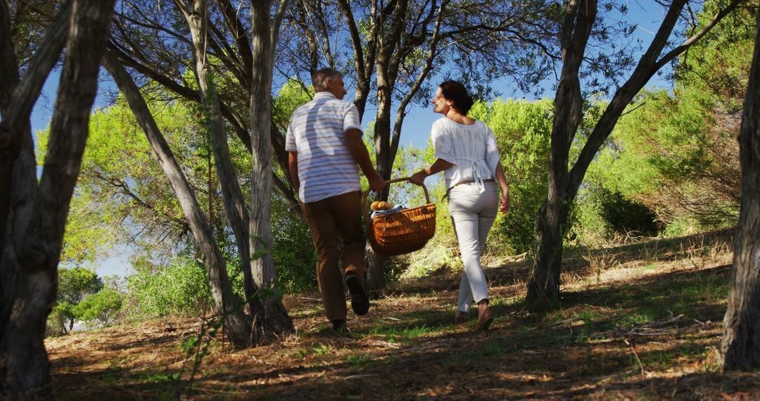 Middle-Aged Couple Enjoying Leisurely Forest Walk with Picnic Basket