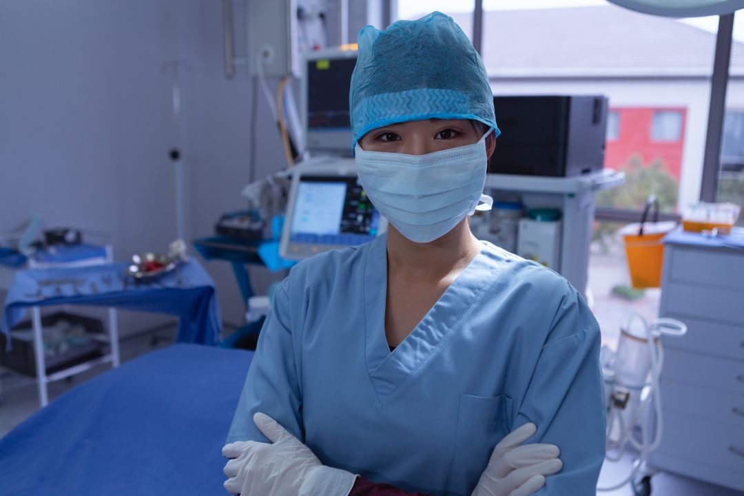 Female surgeon with surgical mask and arm crossed looking at camera in operation room at hospital - Free Images, Stock Photos and Pictures on Pikwizard.com