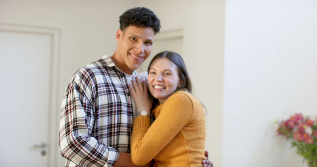 Diverse Couple Smiling Embracing in Cozy Interior
