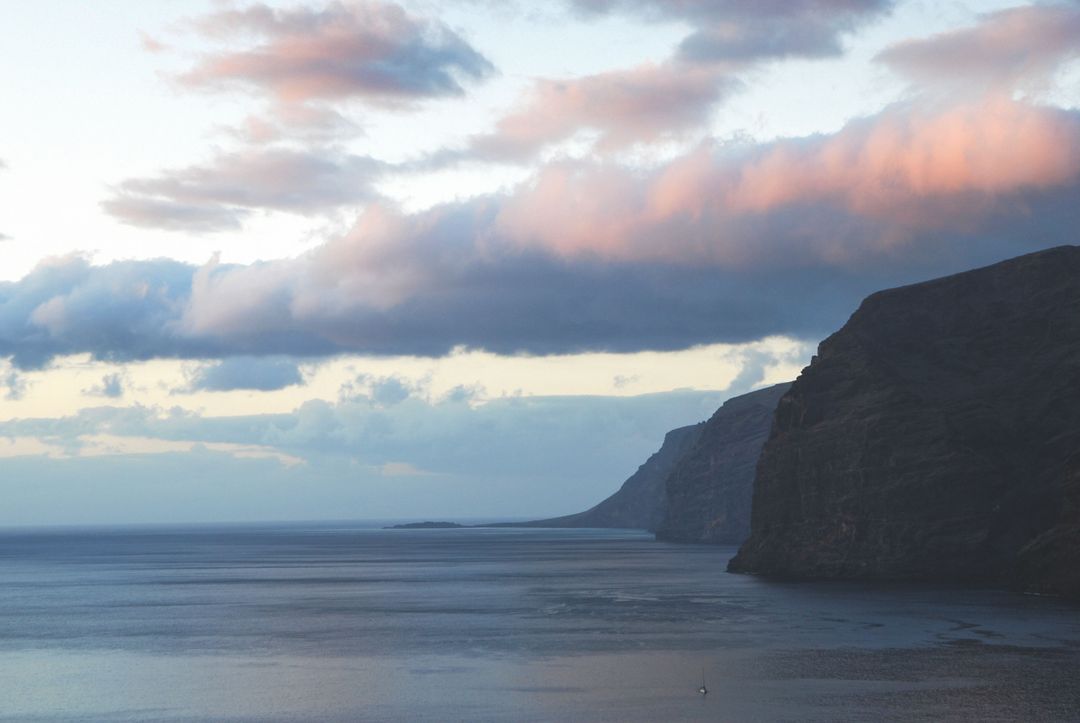 Dramatic Coastal Cliff with Pink Cloudscape During Sunset - Free Images, Stock Photos and Pictures on Pikwizard.com