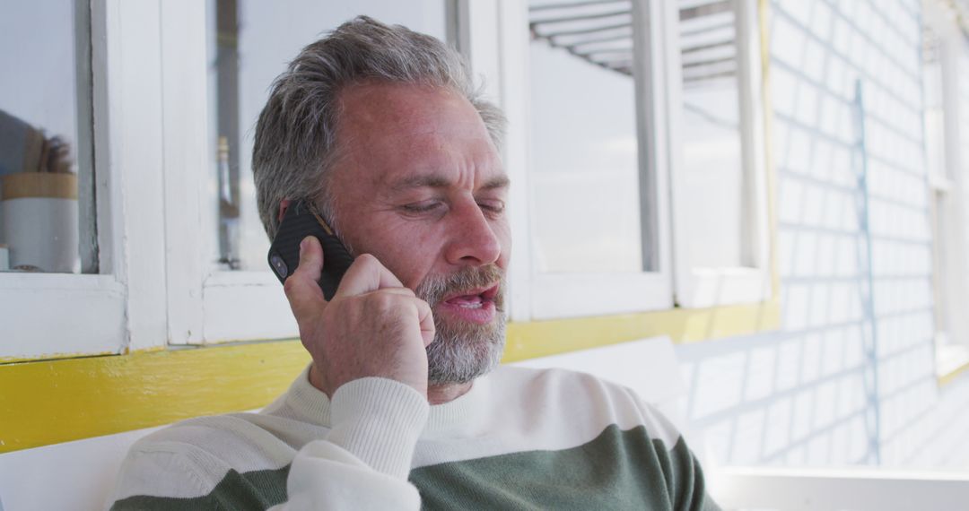 Middle-aged man with beard making call on smartphone outdoors - Free Images, Stock Photos and Pictures on Pikwizard.com