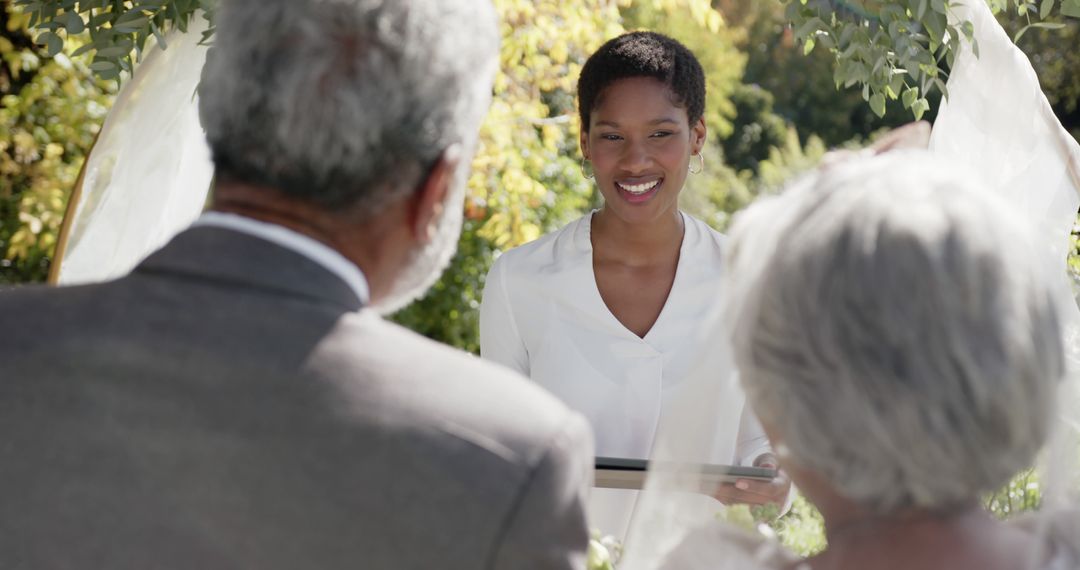 Officiant Smiling at Wedding Ceremony Outdoors - Free Images, Stock Photos and Pictures on Pikwizard.com