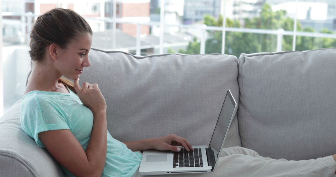 Woman Relaxing on Couch Using Laptop for Remote Work - Free Images, Stock Photos and Pictures on Pikwizard.com