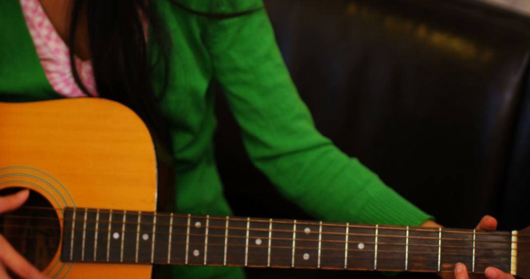 Close-Up of Person in Green Sweater Playing Acoustic Guitar - Free Images, Stock Photos and Pictures on Pikwizard.com