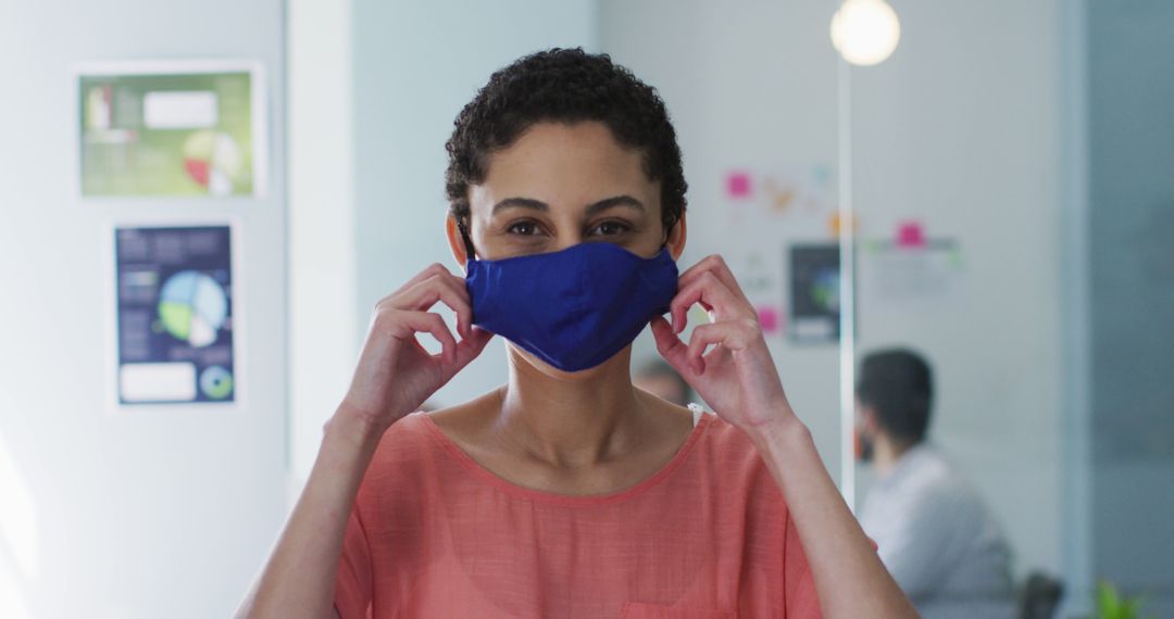 Woman in Office Adjusting Face Mask for Safety