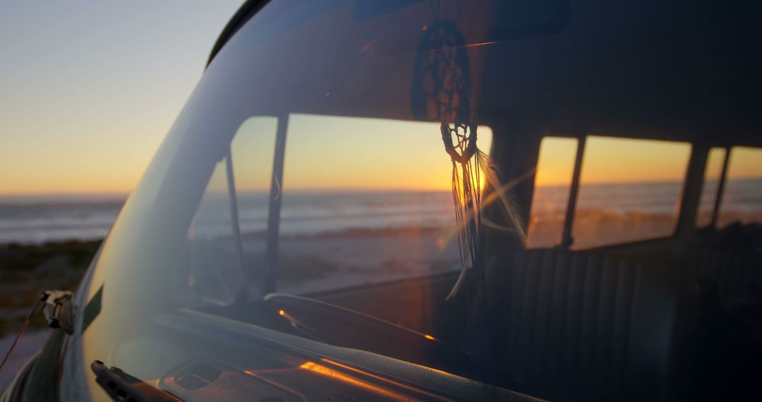 Sunset Reflections on Van Windshield with Dreamcatcher Hanging Inside - Free Images, Stock Photos and Pictures on Pikwizard.com