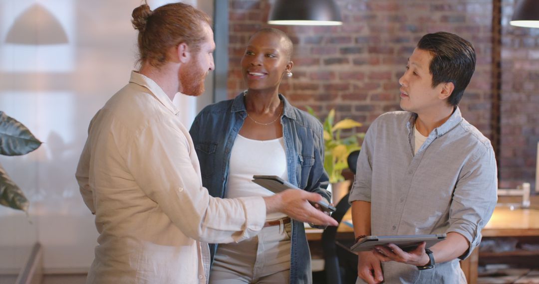 Diverse Team Brainstorming with Tablets in Modern Open Office
